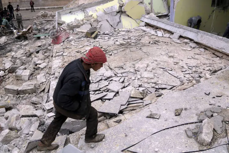 
	Menino olha ru&iacute;nas de sua escola, destru&iacute;da em bombardeio russo em Aleppo: desde setembro de 2015, a avia&ccedil;&atilde;o russa bombardeia &quot;alvos terroristas&quot;
 (Khalil Ashawi / Reuters)