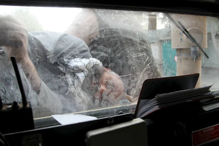 
	Homem ferido &eacute; visto sobre carro militar &agrave; espera de transporte ap&oacute;s conflito com o Taleban em Kunduz, no Afeganist&atilde;o
 (REUTERS/Stringer)