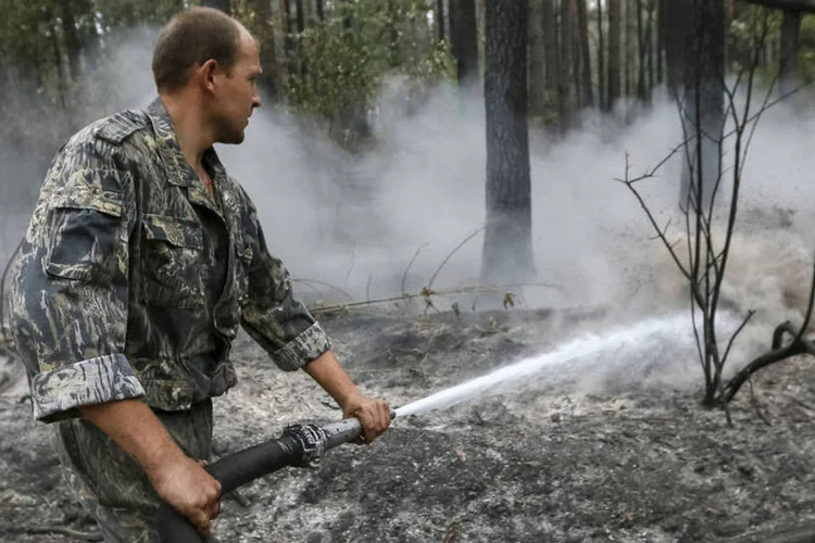 
	Bombeiro apaga inc&ecirc;ndio em floresta perto de Kiev, na Ucr&acirc;nia: inc&ecirc;ndios arrasaram 24 hectares de florestas do noroeste de Kiev nos &uacute;ltimos tr&ecirc;s meses
 (Reutes / Gleb Garanich)