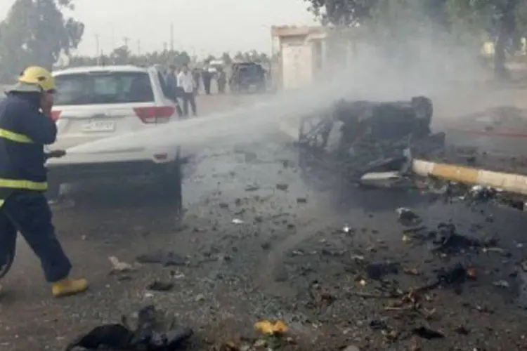 Bombeiro controla fogo de dois carros-bomba que explodiram em Kirkut nesta quinta (Marwan Ibrahim/AFP)