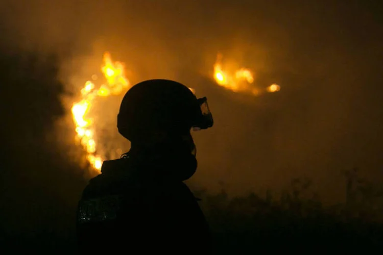 
	Bombeiro apaga fogo causado por foguetes: palestinos dispararam mais de 140 foguetes, diz ex&eacute;rcito
 (Baz Ratner/Reuters)
