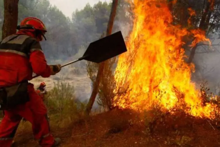 Bombeiro luta contra chamas em uma floresta espanhola (Reuters)