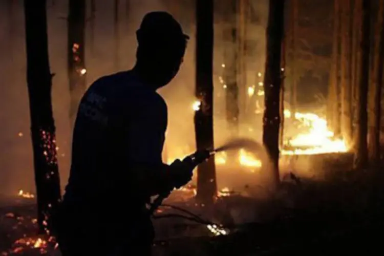 
	Bombeiro russo tenta apagar inc&ecirc;ndio em floresta: segundo as autoridades da Sib&eacute;ria, o fogo n&atilde;o se propagou a centros urbanos nem a infraestruturas
 (Artyom Korotayev/AFP)