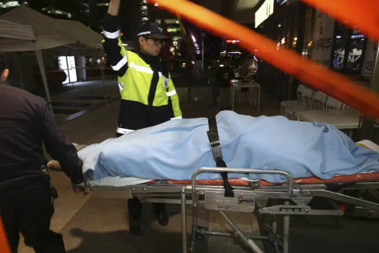 Bombeiros carregam pessoa ferida durante show na Coreia do Sul (Shin Young-keun/Yonhap/Reuters)