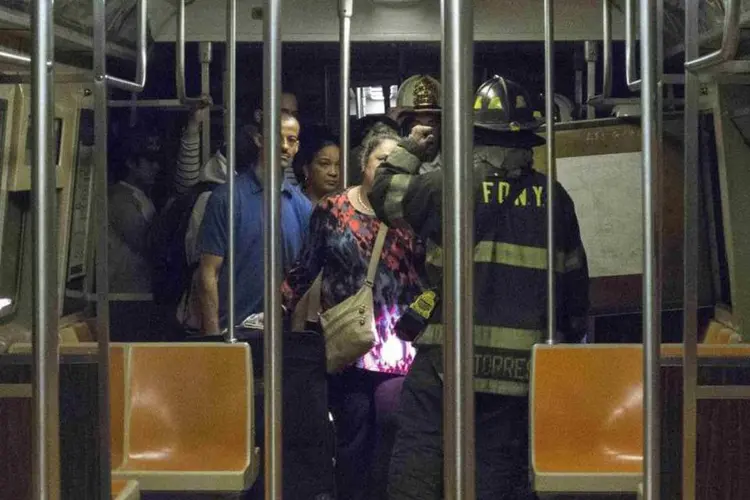 Bombeiros dão instruções a passageiros a saírem de trem do metrô de Nova York: metrô que descarrilou levava aproximadamente mil passageiros (Connie Wang/Reuters)