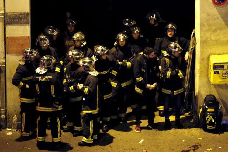 
	Equipe de bombeiros pr&oacute;ximos ao Bataclan, casa de shows onde eram mantidos ref&eacute;ns em Paris
 (Christian Hartmann/Reuters)