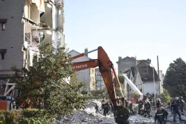 Bombeiros trabalham nos escombros do prédio, no subúrbio de Paris (Martin Bureau/AFP)