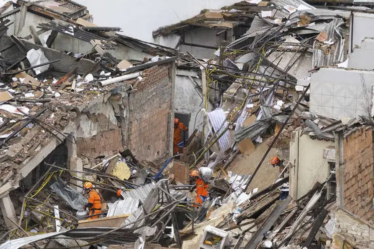 
	Bombeiros vasculham pr&eacute;dio que desabou ap&oacute;s explos&atilde;o no Rio de Janeiro: at&eacute; o momento, 13 pessoas foram ouvidas, entre elas, quatro v&iacute;timas e dois propriet&aacute;rios da Pizzaria Dell&rsquo; Arco
 (Agência Brasil / Tânia Rêgo)