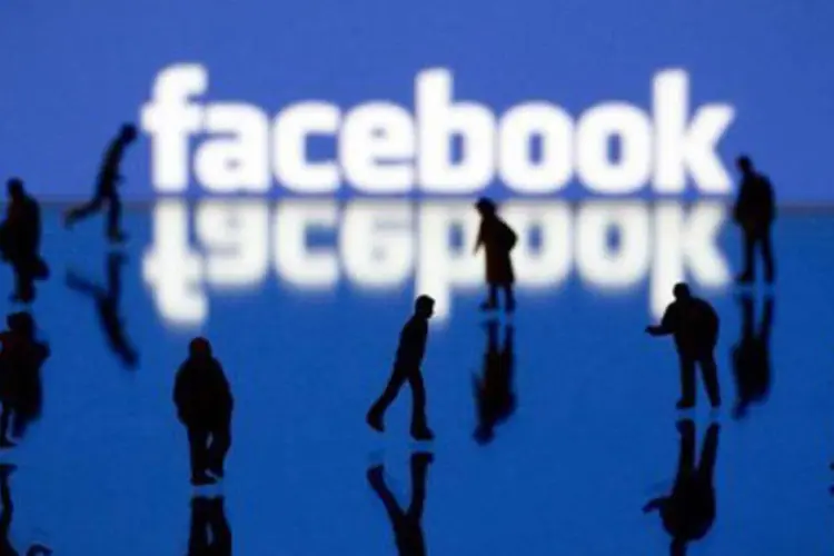 
	Sombras em frente ao logo da rede social Facebook: em setembro, a rede aceitou suspender seu instrumento de reconhecimento facial na Uni&atilde;o Europeia
 (©AFP/Arquivo / Joël Saget)