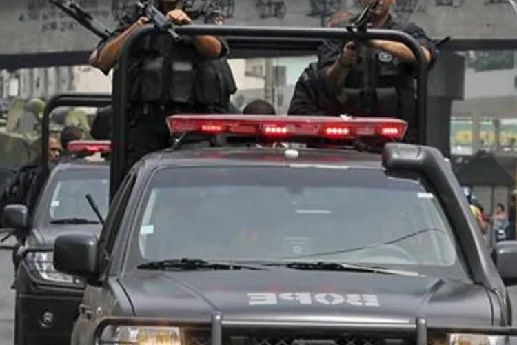 Policiais patrulham rua durante operação na Vila Cruzeiro, cinco dias após atos criminosos (REUTERS)