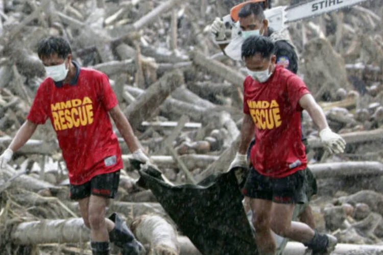 Equipes de resgate carregam corpos de vítimas do tufão "Bopha", recuperados dos escombros arrastados pelas enchentes no sul das Filipinas  (REUTERS / Erik de Castro)