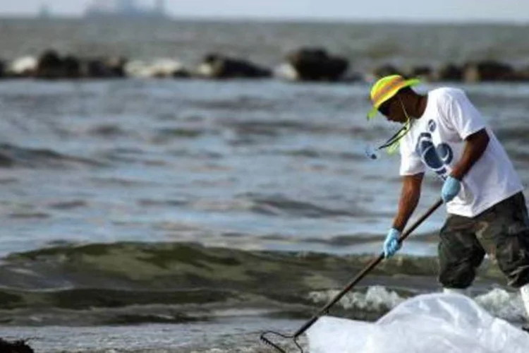 Homem tenta limpar o desastre ambiental na costa dos Estados Unidos: mais de 51 mil pedidos de indenização foram submetidos à empresa até agora. (.)