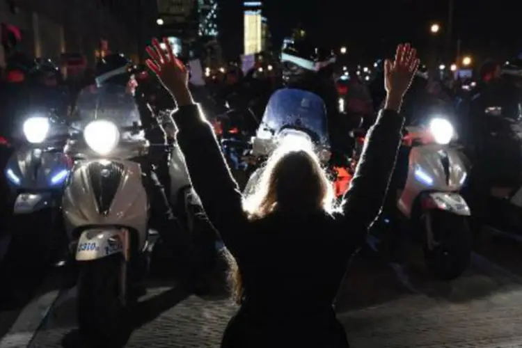 Manifestante ergue os braços em frente a policiais, durante bloqueio de avenida em Nova York (Timothy A. Clary/AFP)