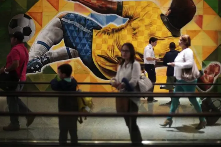 Passageiros passam por pintura para a Copa no aeroporto de Brasília (REUTERS/Ueslei Marcelino)