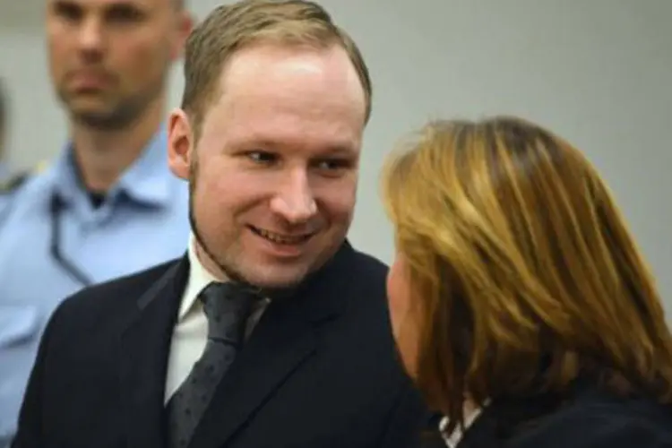 
	Anders Behring Breivik (C) sorri ao conversar com sua advogada no tribunal de Oslo nesta sexta: foi tamb&eacute;m com um sorriso que ele recebeu sua condena&ccedil;&atilde;o a 21 anos de pris&atilde;o
 (Odd Andersen/AFP)