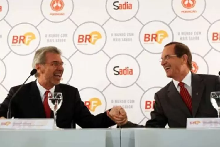 O presidente da Perdigão, Nildemar Secches (à esquerda), e o presidente do grupo Sadia, Luiz Fernando Furlan (à direita), comemoram o fim do projeto "7 Belo", que resultou na criação da Brasil Foods (.)