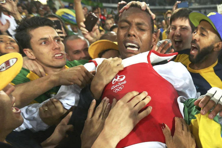 Maicon Siqueira, do Brasil, comemora com amigos e familiares a conquista da medalha de bronze no taekwondo, categoria mais de 80kg. Ele venceu o britânico Mahama Cho. (REUTERS/Issei Kato)