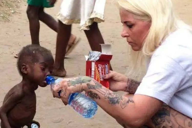 
	Volunt&aacute;ria de ONG alimentando uma crian&ccedil;a de 2 anos rejeitada pela sua comunidade na Nig&eacute;ria
 (Reprodução/Facebook)