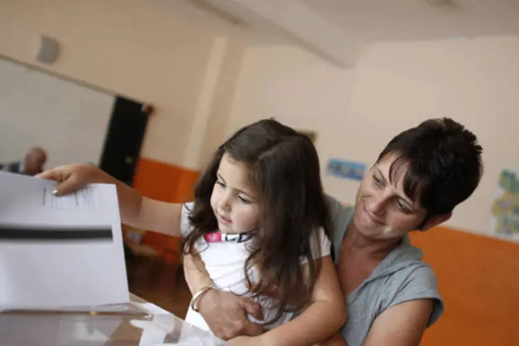 
	Mulher vota com sua filha em S&oacute;fia: Uma em cada quatro pessoas vive abaixo da linha da pobreza no pa&iacute;s
 (Reuters/Stoyan Nenov)