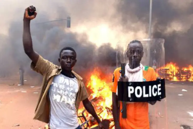 
	Manifestantes posam em frente ao parlamento de Burkina Faso: Compaor&eacute; renunciou ap&oacute;s protestos que exigem sua sa&iacute;da ap&oacute;s 27 anos no poder
 (Issouf Sanogo/AFP)