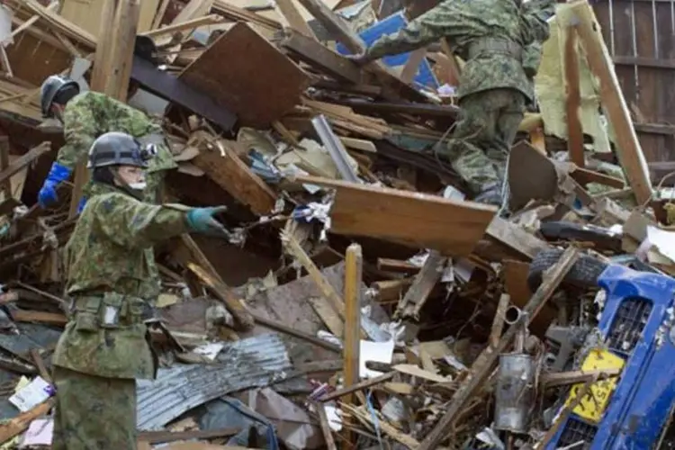 Equipe busca vítimas do tsunami em Ishinomaki, a cidade mais devastada pelo fenômeno, onde morreram 3,8 mil pessoas e 50 mil perderam suas casas (Paula Bronstein/Getty Images)