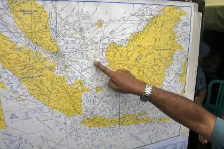 Funcionário da aviação indonésia analisa mapa em 29 de dezembro de 2014 no aeroporto de Surubaya (Juni Kriswanto/AFP)