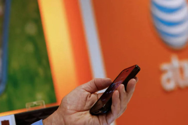 Funcionário da AT&T com um iPhone, da Apple, em uma loja da companhia em Manhattan Beach, Califórnia (Patrick T. Fallon/Bloomberg)