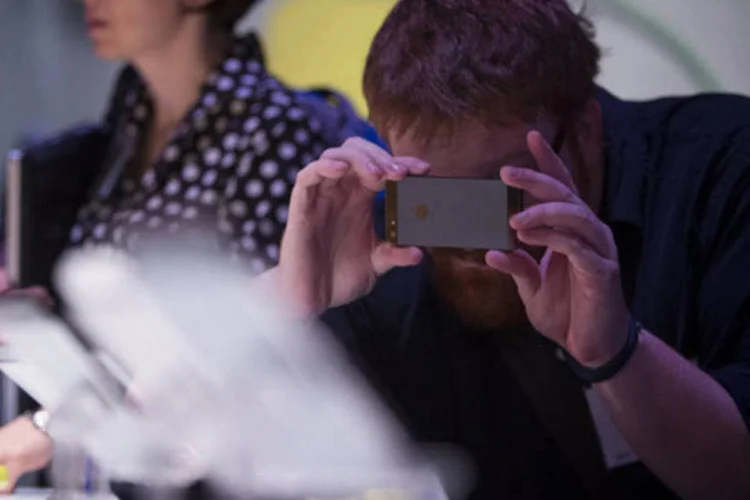 Homem fotografa Motorola Moto X com um iPhone, da Apple, durante evento de lançamento do smartphone em agosto de 2013, na cidade de Nova York (Scott Eells/Bloomberg)