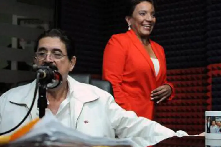 O presidente hondurenho deposto Manuel Zelaya, faz coletiva de imprensa ao lado da mulher, Xiomara Castro, em 27 de novembro de 2013 (Orlando Sierra/AFP)