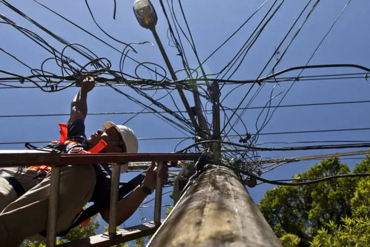 
	Oper&aacute;rio instalando cabos em um poste de energia el&eacute;trica em Santa Teresa, no Rio de Janeiro
 (Dado Galdieri/Bloomberg)