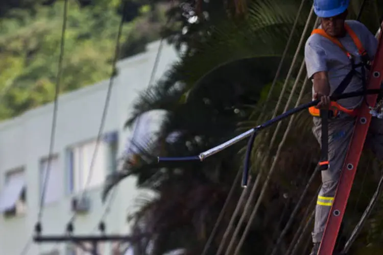 Trabalhador consertando cabos em um poste de eletricidade no bairro das Laranjeiras, no Rio de Janeiro (Dado Galdieri/Bloomberg)