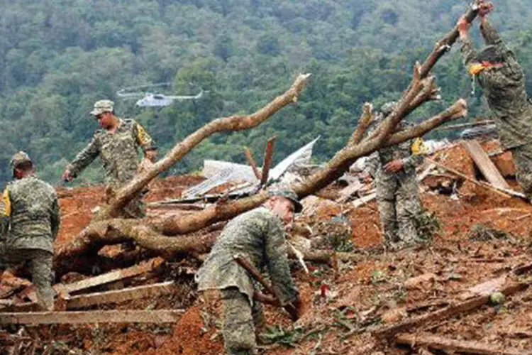 Equipes de resgate trabalham para encontrar dezenas de pessoas desaparecidas após um deslizamento de terra que devastou uma pequena localidade no sul do México (Pedro Pardo/AFP)