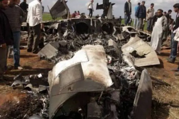 O F-15 destruído na Líbia, cercado de curiosos (Patrick Baz/AFP)