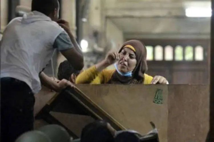 Mulher conversa com policiais de dentro da mesquita Al-Fath, no Cairo (©afp.com / Mohamed el-Shahed)