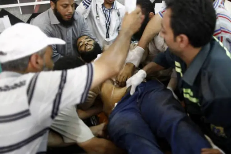 Homem ferido é levado para hospital no Cairo após os confrontos entre a polícia e simpatizantes do presidente deposto do Egito Mohamed Mursi (AFP / Mahmoud Khaled)