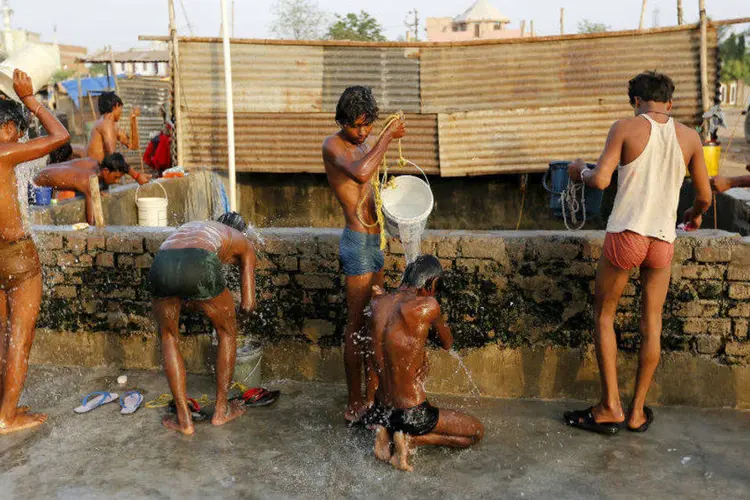 
	Trabalhadores da constru&ccedil;&atilde;o se banham antes de terminar seu dia de trabalho debaixo do calor da &Iacute;ndia
 (Amit Dave/Reuters)