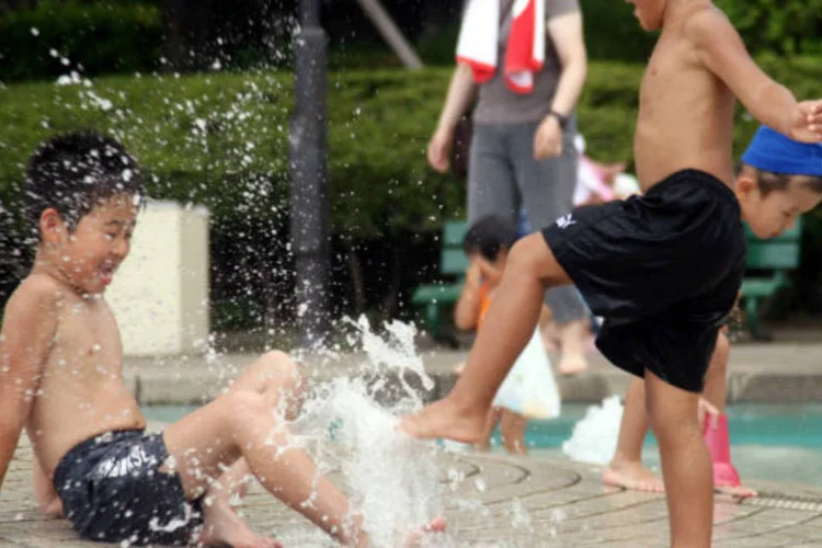 
	Calor: crian&ccedil;as brincam em fonte de parque no Jap&atilde;o
 (Haruyoshi Yamaguchi/ Bloomberg)