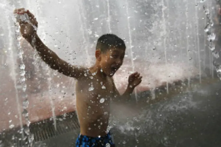Criança se refresca de calor em fonte de Xangai, na China (REUTERS/Carlos Barria)