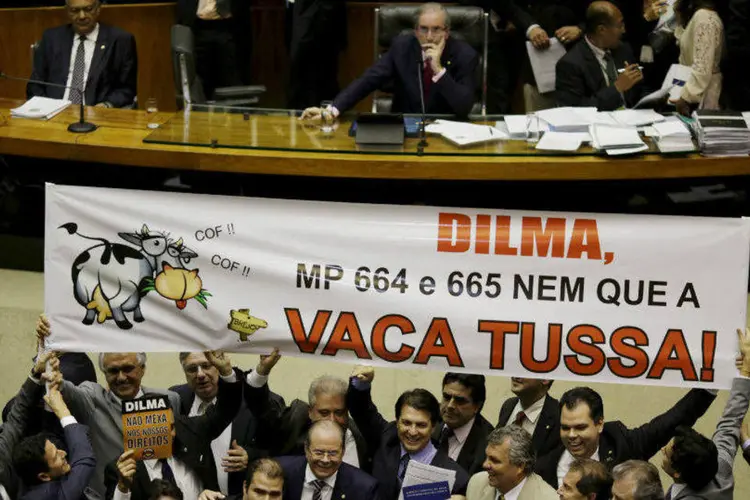 Deputados seguram cartaz contra votação a MP 664 e 665 na Câmara dos Deputados, em Brasília (Ueslei Marcelino/Reuters)