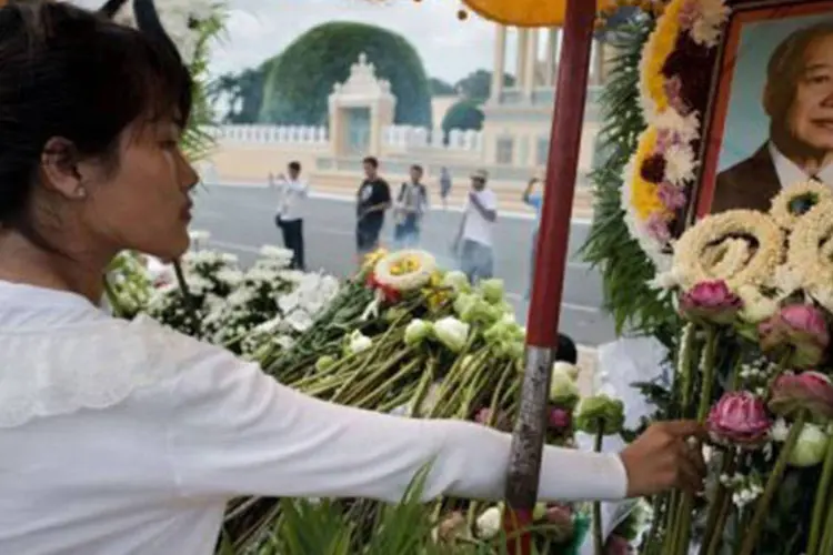 
	Cambojana deposita flores junto a retrato do falecido rei Norodom Sihanouk: o pa&iacute;s iniciou uma semana de luto nacional (Nicolas Asfouri/AFP)