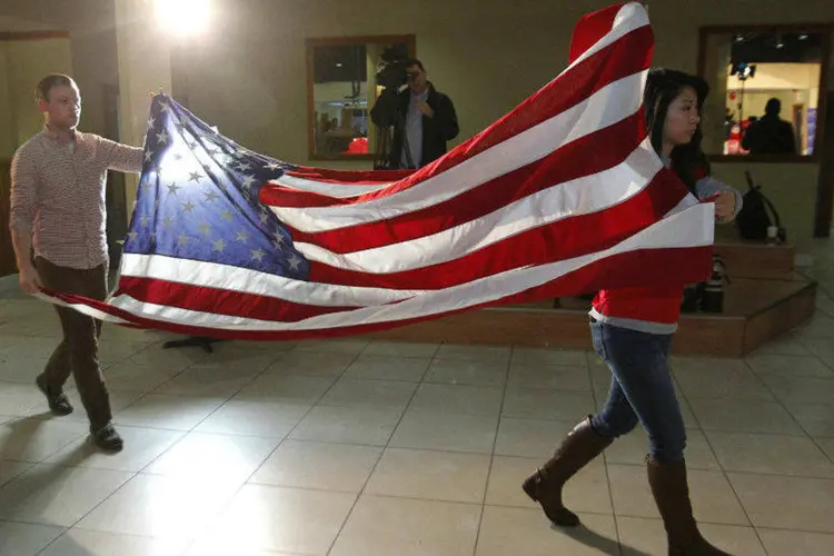 Voluntários carregam bandeira americana durante campanha do senador Mitch McConell (John Sommers II/Reuters)