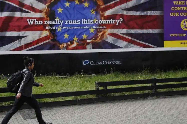 Pedestre passa por um poster da campanha eleitoral do Partido pela Independência (Ukip) em Vauxhall, centro de Londres (Luke MacGregor/Reuters)