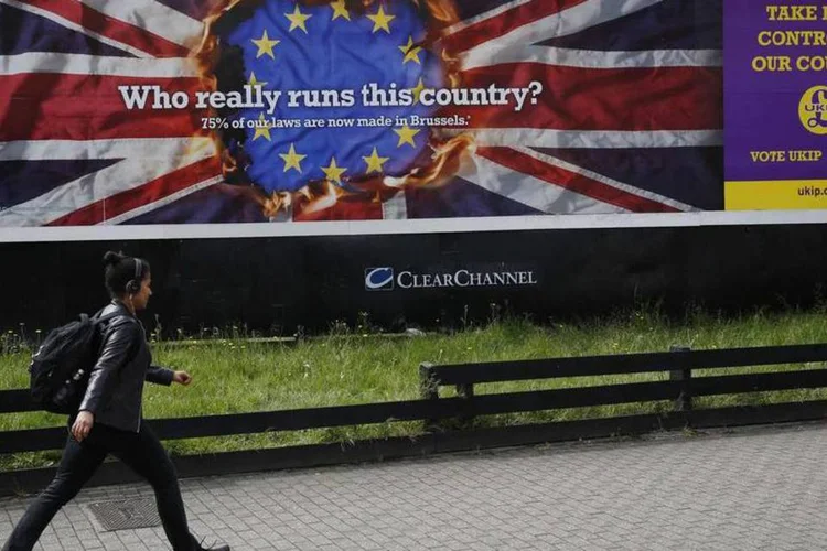 
	Pedestre passa por um poster da campanha eleitoral do Partido pela Independ&ecirc;ncia (Ukip)
 (Luke MacGregor/Reuters)