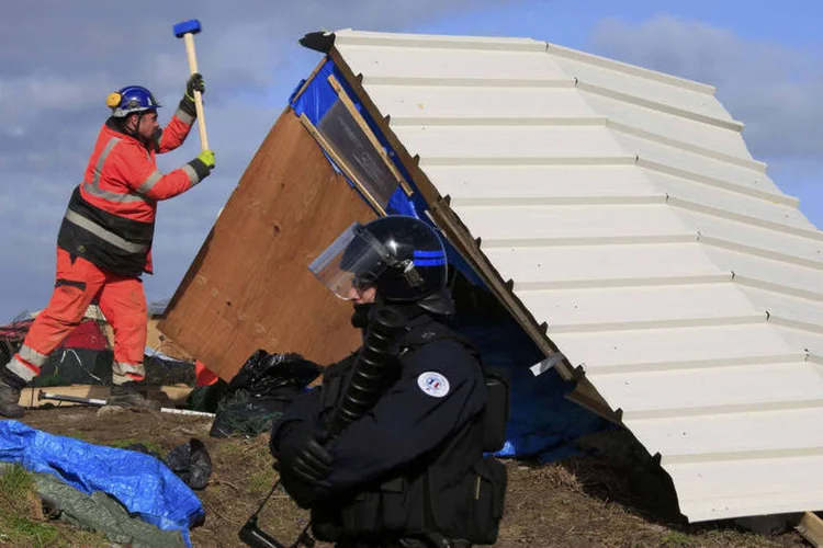 
	Calais: v&aacute;rios migrantes se encontravam ainda presentes para recuperar pertences para se transferir a outro ponto um pouco mais distante
 (Pascal Rossignol / Reuters)