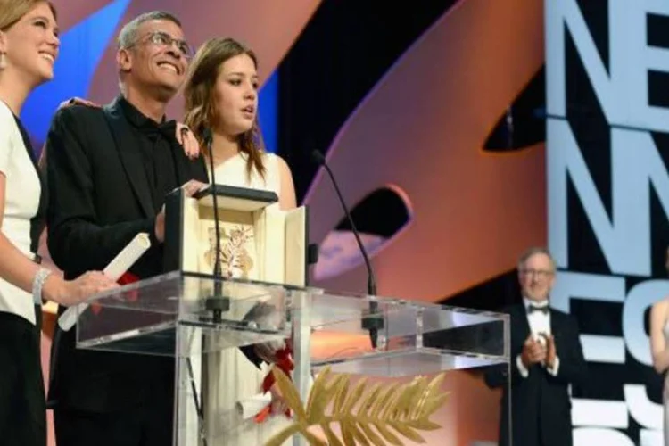 Abraçados e chorando no palco, as duas atrizes e o diretor agradeceram pela Palma (Getty Images)