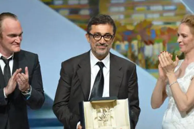 
	Nuri Bilge posa com a Palma de Ouro entre Tarantino Uma Thurman
 (ALBERTO PIZZOLI/AFP)