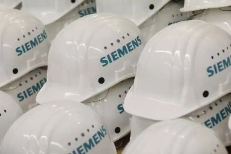 
	Capacetes da Siemens: a companhia alem&atilde; explicou que ser&aacute; &quot;instalado um sistema de cabos a&eacute;reos para caminh&otilde;es h&iacute;bridos na Su&eacute;cia&quot;
 (Michele Tantussi/AFP)