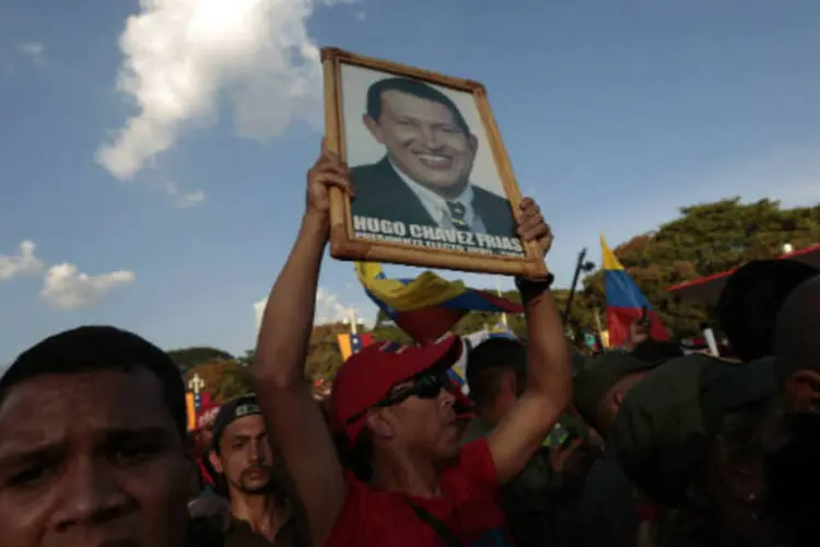 Apoiador de Hugo Chávez carrega um retratodo presidente durante cortejo nas ruas de Caracas  (REUTERS / Jorge Dan Lopez)