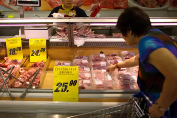 
	Consumidora escolhendo carne em um supermercado em Hong Kong, na China
 (Lam Yik Fei/Bloomberg)