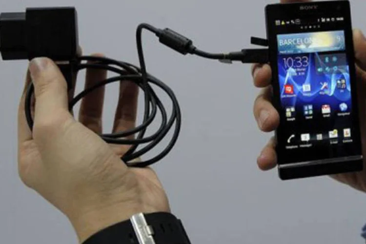 
	Carregador conectado a aparelho da Sony Ericsson: acordo ser&aacute; implementado por volta de 2017
 (Lluis Gene/AFP)